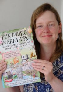 Photo of Claire with a preview copy of her book, Fun Music Warm-Ups